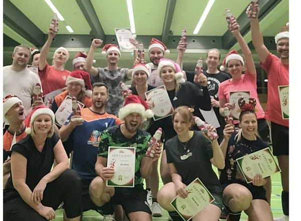 Volleyball-Gruppe mit Nikolausmützen und Urkunden in der Sporthalle